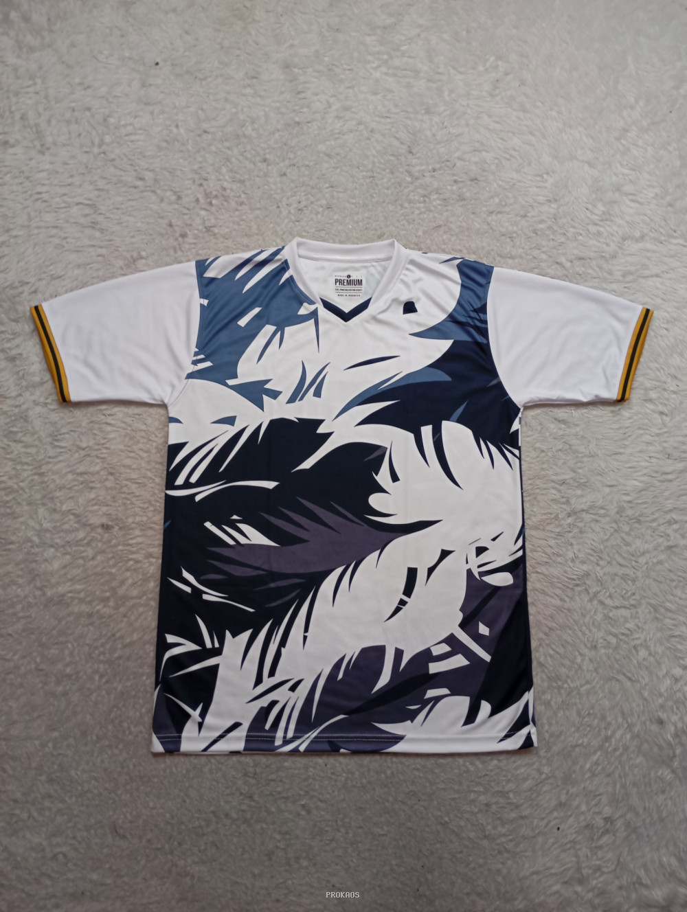 Jersey Putih dengan Motif Daun Abstrak dan Detail Emas - Jersey Custom PROKAOS