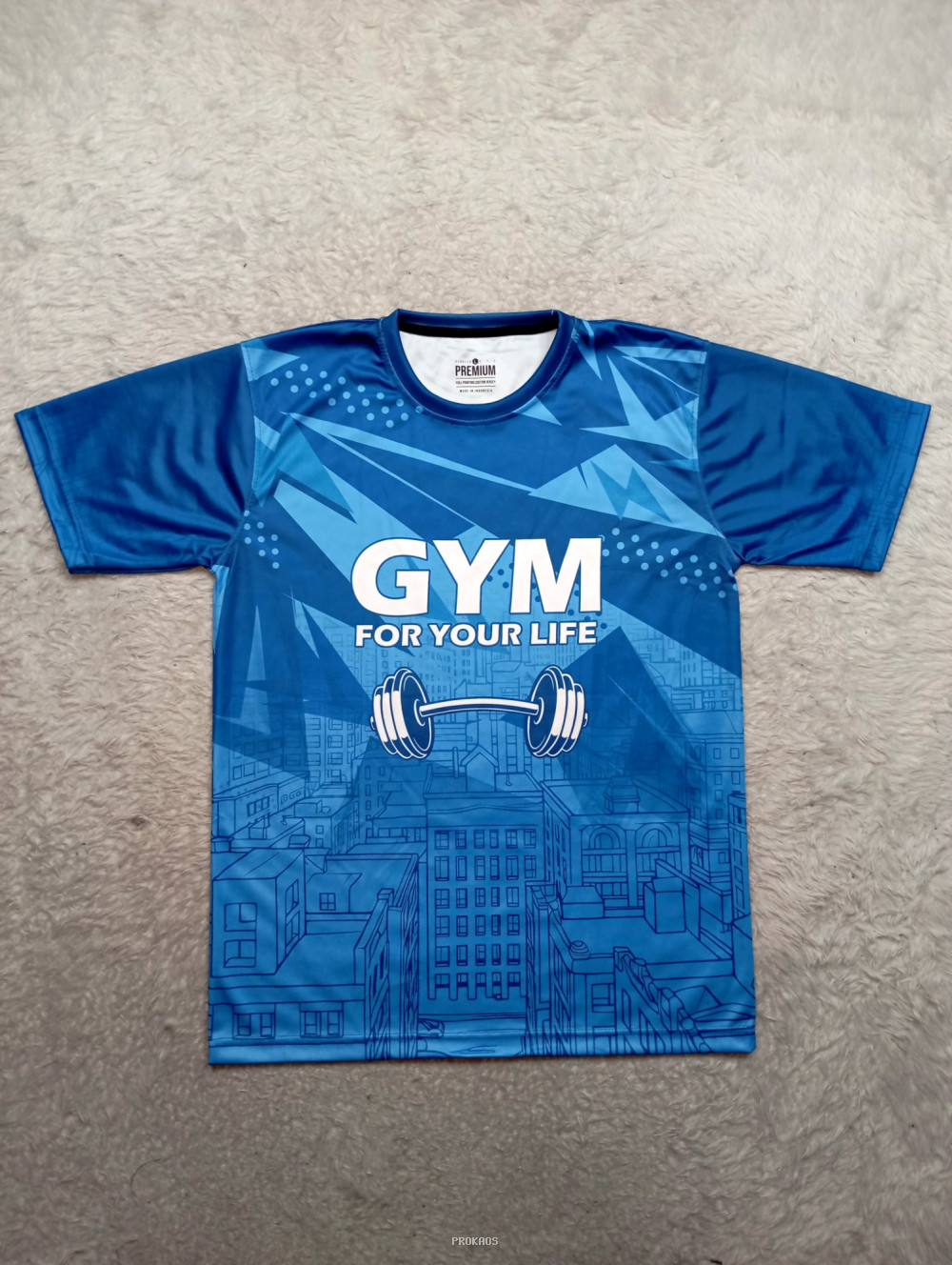 Kaos Gym Biru: Desain Dinamis dengan Barbells & Kota - Jersey Custom PROKAOS
